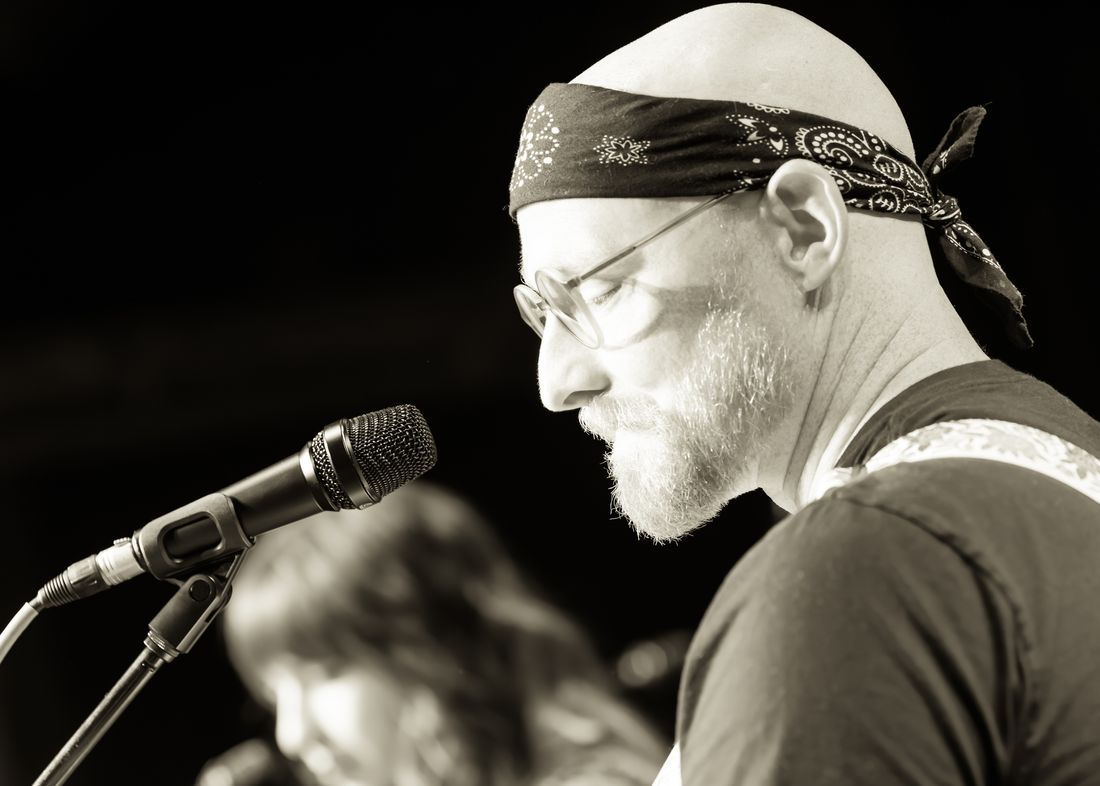 Jon at a microphone during a live performance.
